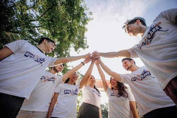 des collaborateurs sont réunis et se tapent dans la main durant un team building de cohésion d'équipe.