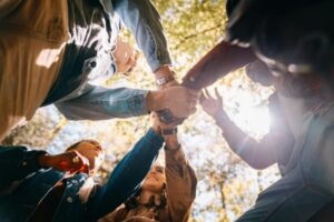 un groupe de collaborateurs se tape dans la main pour sceller leur cohésion d'équipe.