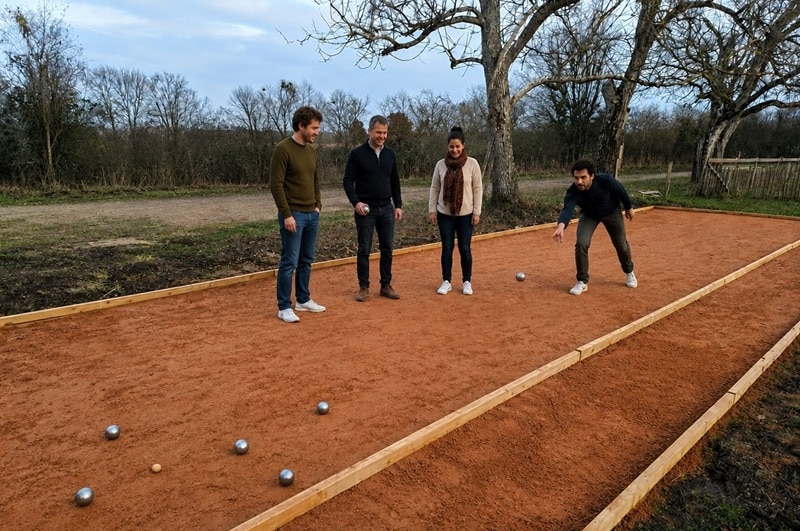 un groupe de collaborateurs profite d'une partie de pétanque durant une activité de team building.